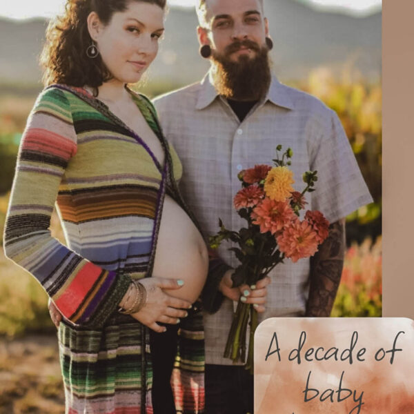 smiling pregnant women and husband posing with flowers